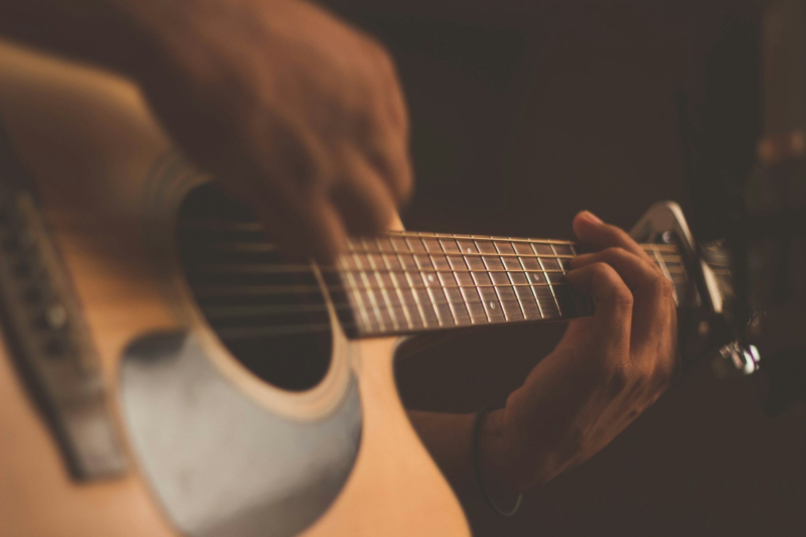 An acoustic guitar in warm half-light — the stage gear of Flagship Romance