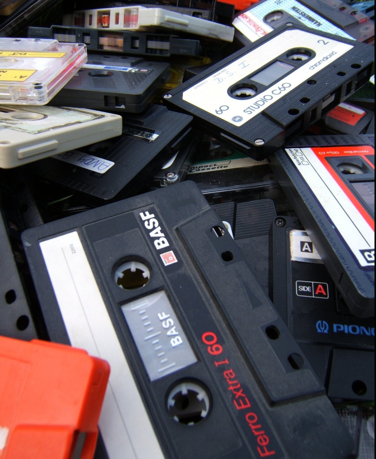 A heap of old compact cassettes, several with handwritten labels