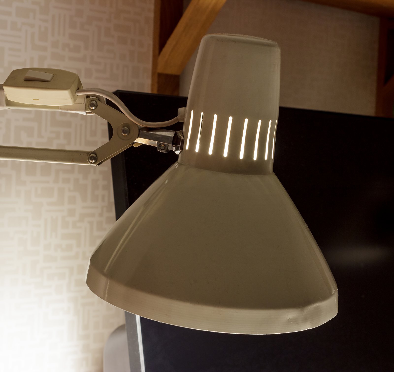 An old desk lamp angled over a writing surface — the visual register of late-night listening