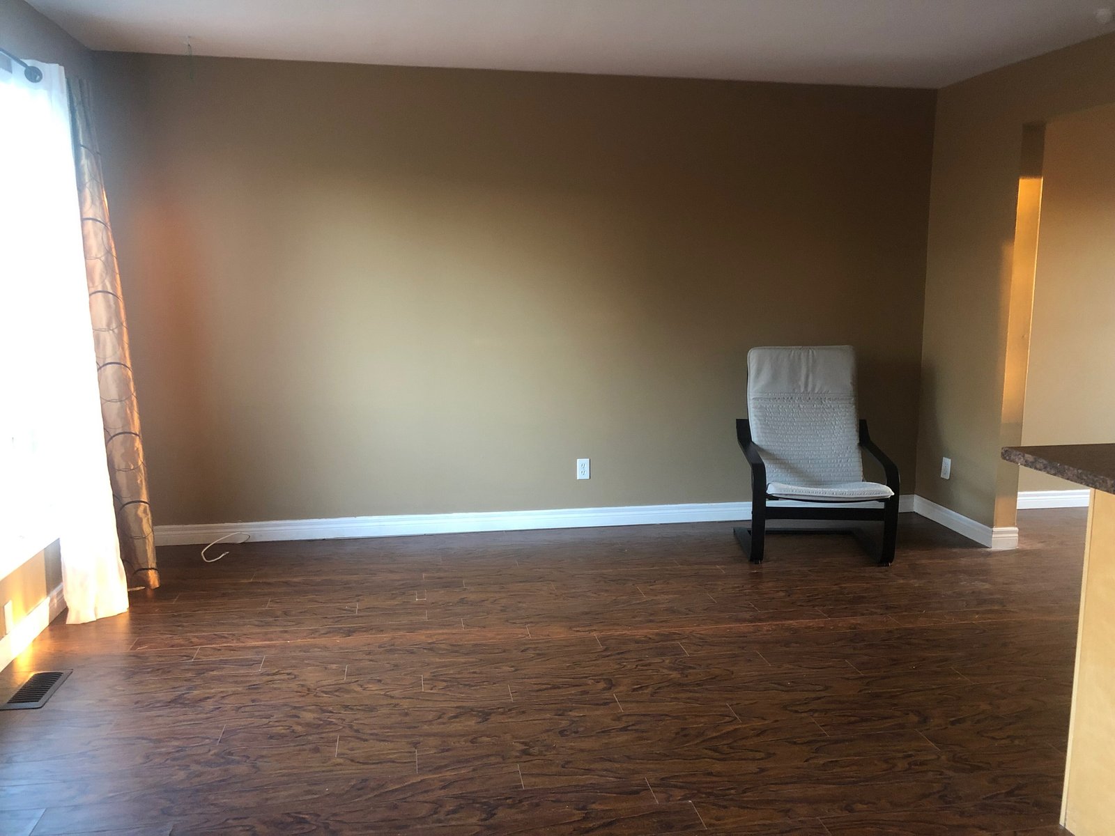 An almost empty room with a single chair near the window — the structural register of silence