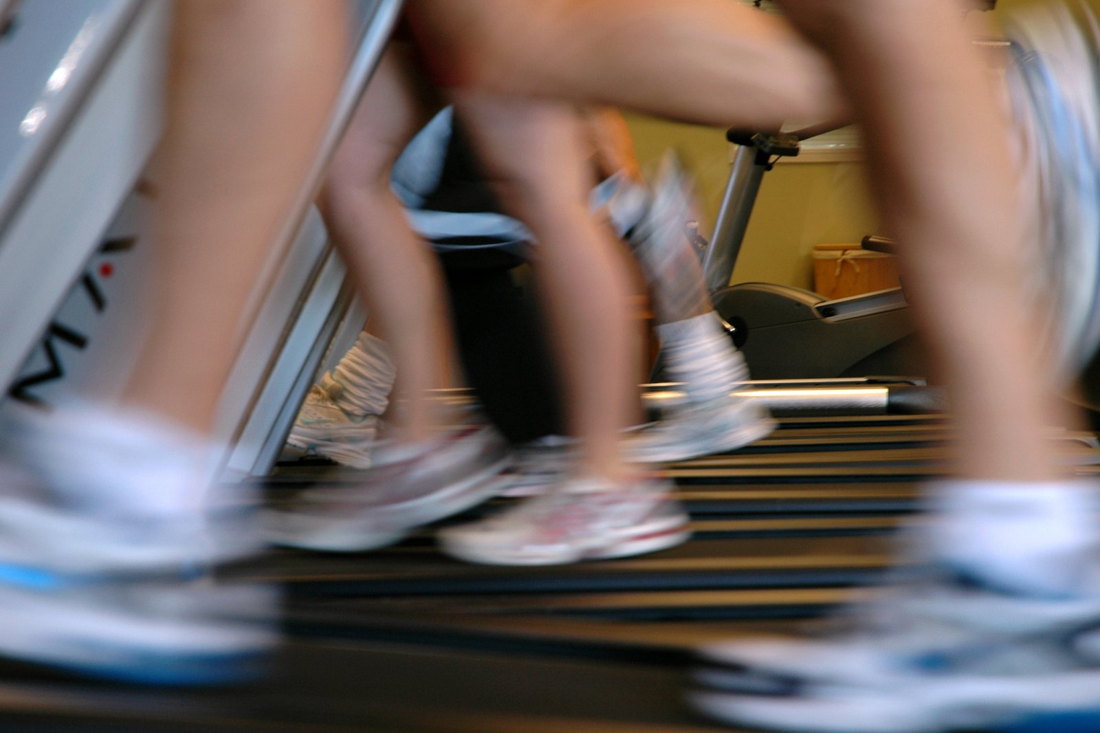 Runners on treadmills captured in motion blur — the visual register of activation