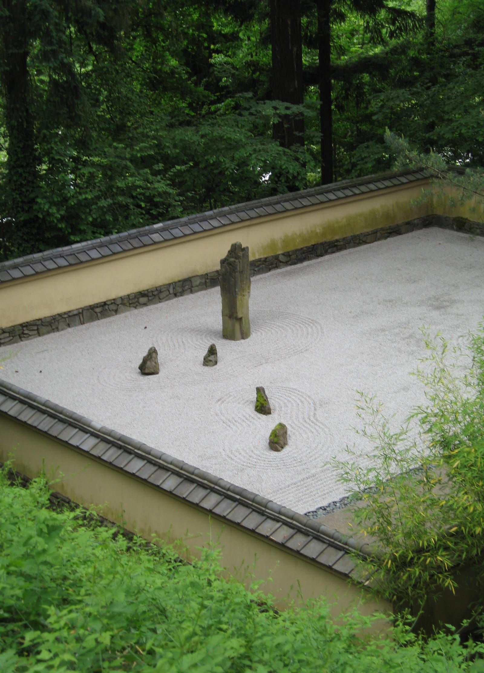 A traditional Japanese zen garden with raked gravel and stones — the visual register of meditative attention